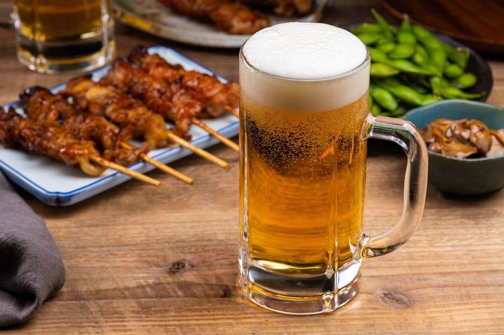居酒屋のテーブルにビールと焼き鳥やおつまみ
