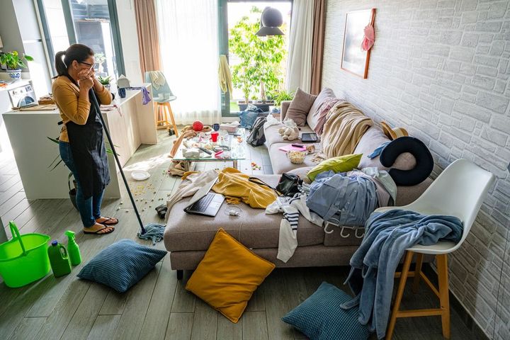 いざ掃除をしようとして、あまりの乱雑さに困惑している女性