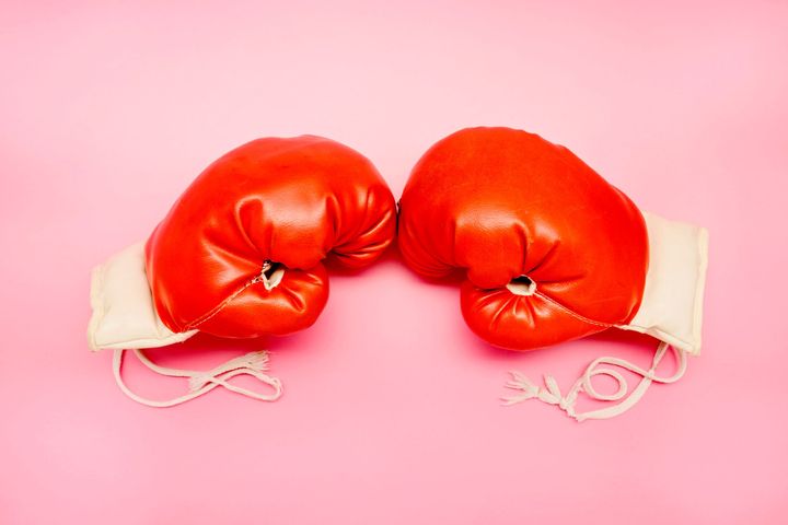 Pair of red boxing gloves on pink background