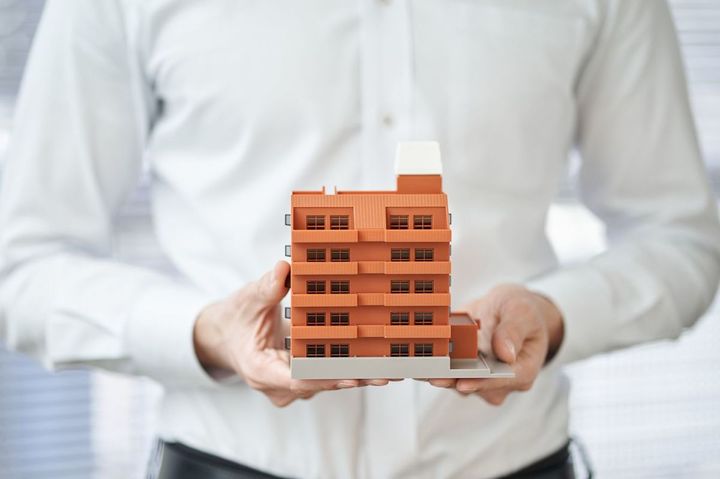 アパートの建築模型を持つ手
