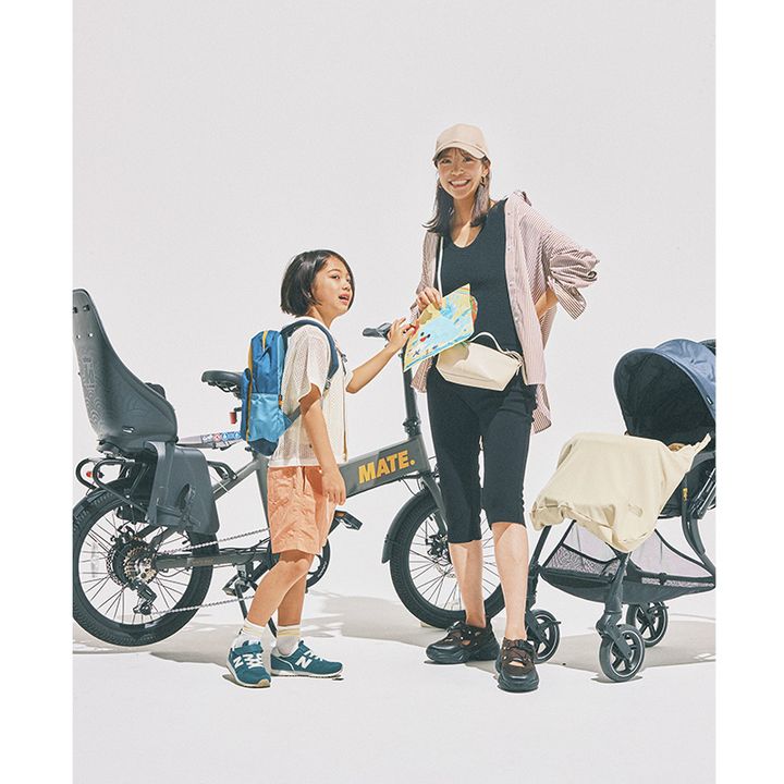 自転車とベビーカーの前に立っている黒タンクと膝下レギンスにストライプ柄のUVシャツを羽織ってキャップやスニーカーサンダルを合わせたママと男の子
