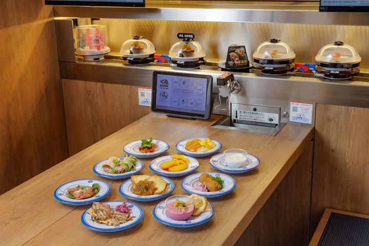 万博店では通常のメニューと同様に、世界の料理も「ハンズ・ハンズⓇPROJECT」の特製2連皿で回転レーンに流れてくる。70メニューがタブレットからも注文可能