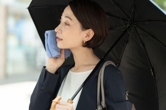 ハンカチで汗を拭く女性