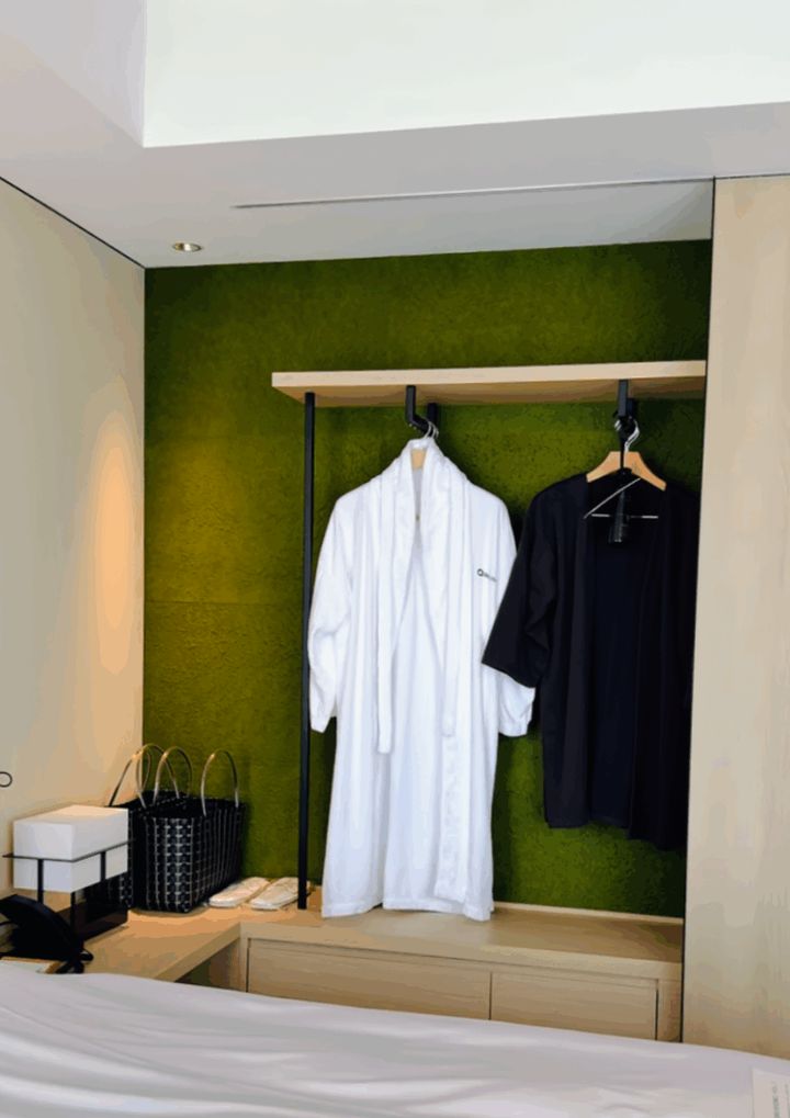 扉をスライドするとバスローブがかかるクローゼットが現れました。背面の緑の壁がアクセントになっています。