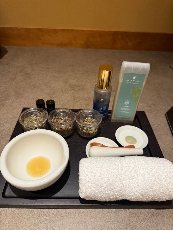 の前でブレンドされたハーブでフットのマッサージを受けました