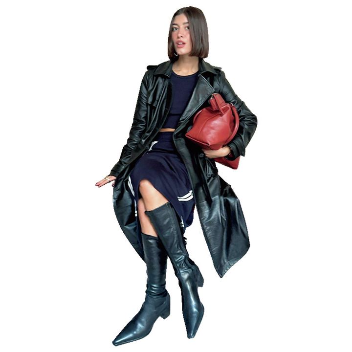 レザージャケットとロングブーツで決めている女性