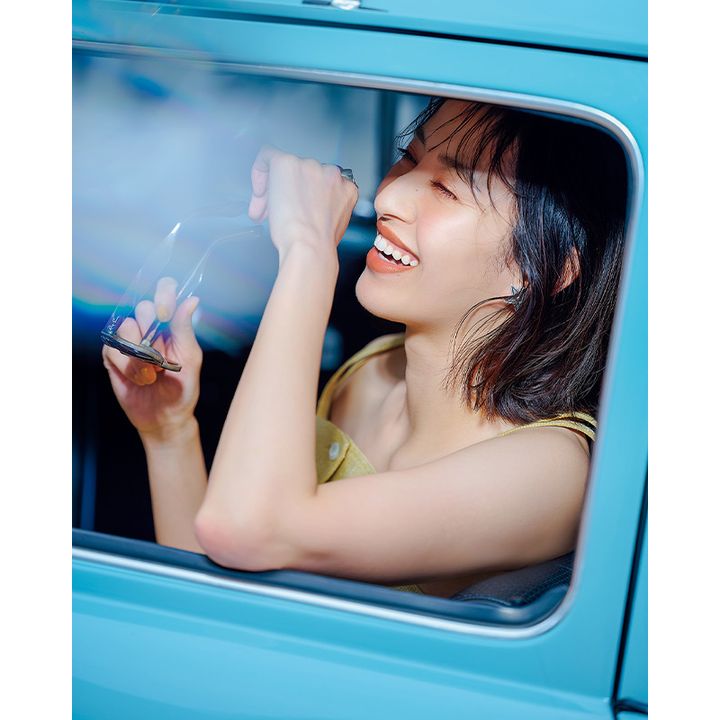 車に乗ってサングラスをとっているイメージカット