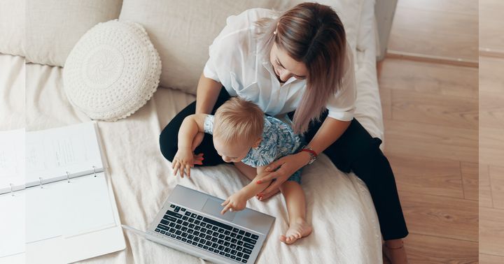 お母さんが赤ちゃんとパソコンを触るイメージカット