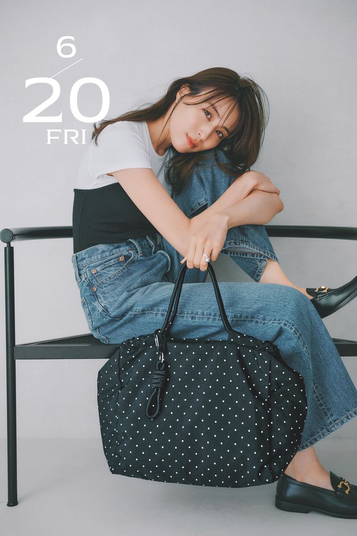 白Tにビスチェを重ねた風のトップスとデニムにドット柄のビッグトートとローファーを合わせた笹川友里さん