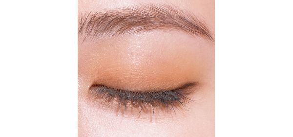 トーンのオレンジシャドウを上まぶたの目頭〜黒目の外側まで重ねて目元に軽さを出す