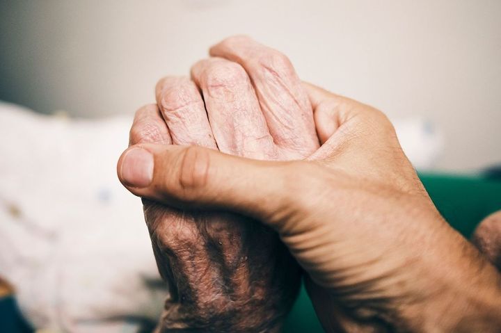 高齢者の手を握る