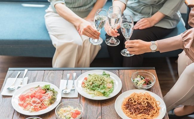 食事とシャンパンを楽しむ3人の女性