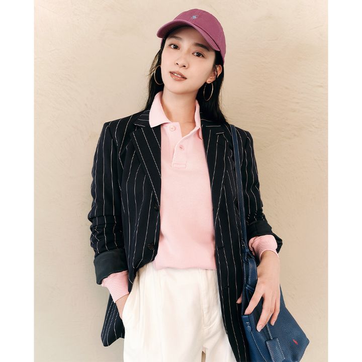 ラルフローレンのピンクのスウェット地のポロシャツと白パンツにストライプ柄のジャケットを羽織ってキャップとネイビーのバッグを合わせた武井咲さん