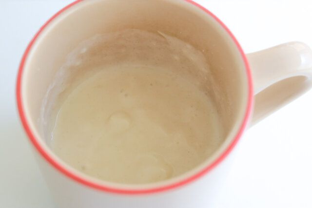 マグカップにホットケーキミックスを入れ、牛乳、砂糖、米油を加えてスプーンで混ぜ合わせる。