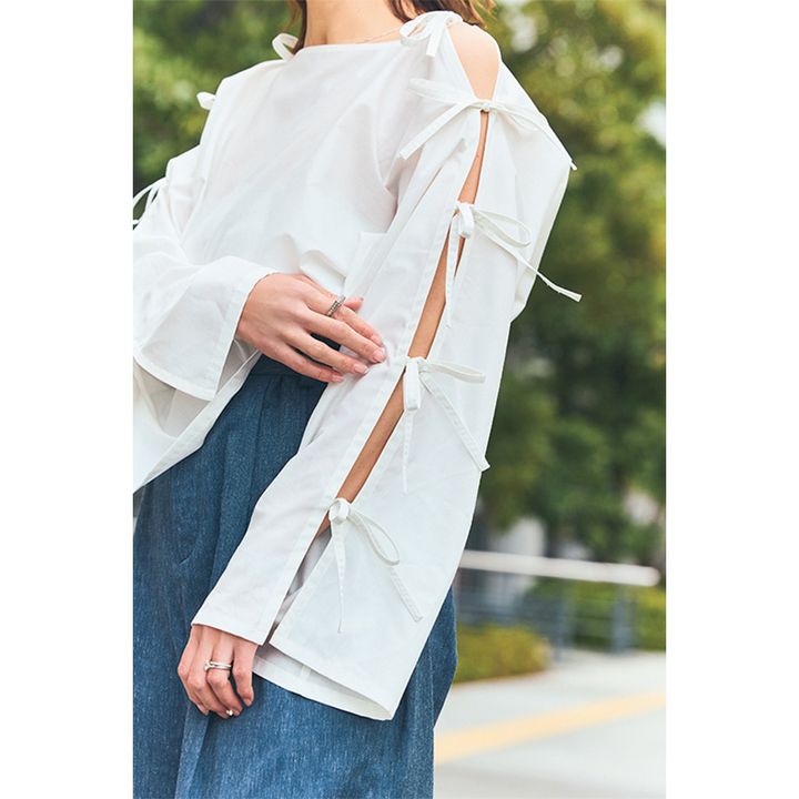 シーニュのリボンからチラリとのぞく肌見せがフェミニンなトップス