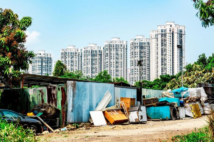 高層ビルを背景に放棄された家
