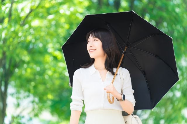 内側が黒、外側が白の日傘をさす女性 紫外線 熱中症対策