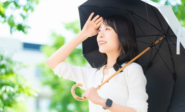 内側が黒、外側が白の日傘をさす女性 紫外線 熱中症対策