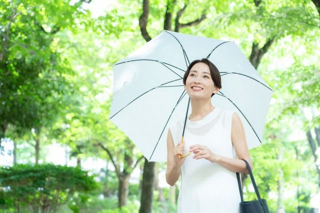 新緑の避暑地を散歩するミドルの女性 紫外線 熱中症対策