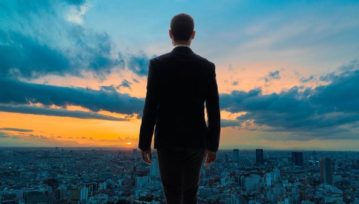 空を眺める男性の後ろ姿