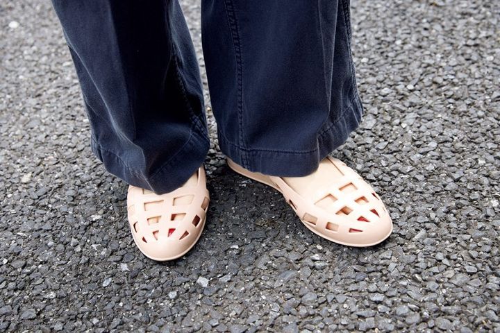 ヌーディーな色味とシルエットが女性らしいエンシェントグリークサンダルズのシューズは、ラバー素材で黒ベースの装いを軽やかに！