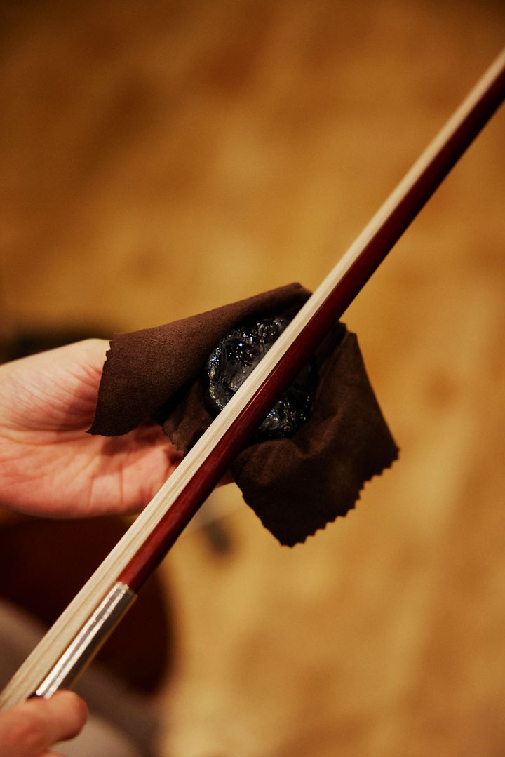 弓の毛に松脂をつける様子