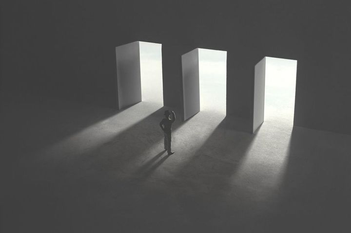 3つのドアの前で悩む男