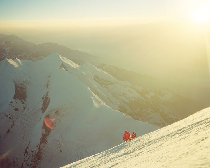 ヒマラヤ、ダウラギリⅠ峰（8,167ｍ）。頂上直下の斜面で迎えた日の出。撮影した石川直樹さんいわく「ダウンスーツの上からでもその温もりを実感した」瞬間。