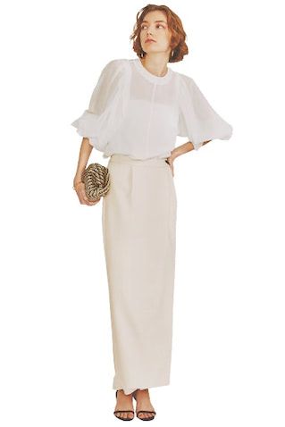 白ボリュームスリーブブラウス 15,400円／バビロン（エレメントルール カスタマーサービス） キナリラップスカート 14,080円／SeaRoomlynn クラッチバッグ 24,200円、黒サンダル 19,800円／ともにルル・ウィルビー（アルアバイル） ピアス 14,630円、ゴールドバングル 16,390円／ともにSOKO（ZUTTOHOLIC） 辛さが残る直線的なスカートなら、甘いブラウスと合わせてもガーリーに転ばない。