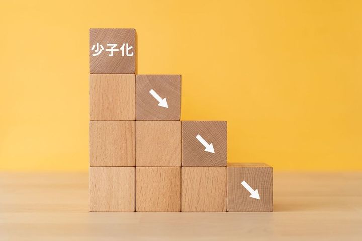 木製ブロックに「少子化」の文字。右肩下がりで下降を示している