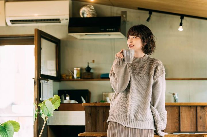 立ってコーヒーを飲む女性