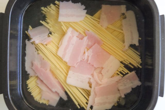 ベーコンをちぎって加え、ラップをせずにレンジ600Wで10分加熱する。