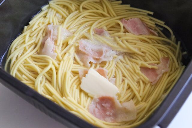 加熱が終わったスパゲッティにバターを加えて混ぜ合わせる。