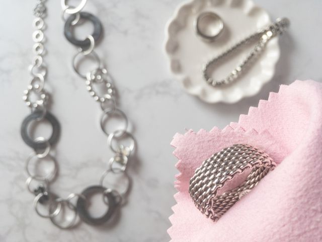 ピンクのクロスでシルバーアクセサリーを拭き取る様子