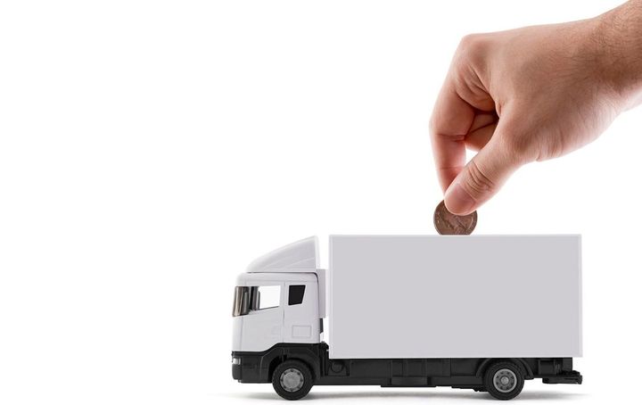 貨物配達トラックの模型にお金を入れる手