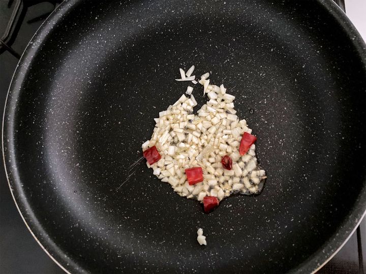 フライパンにゴマ油を熱して、にんにくと鷹の爪を炒める