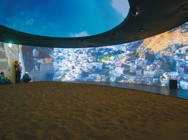 砂漠の上で、周囲の壁や天井に映し出されるヨルダンの自然風景や星空の映像を鑑賞。