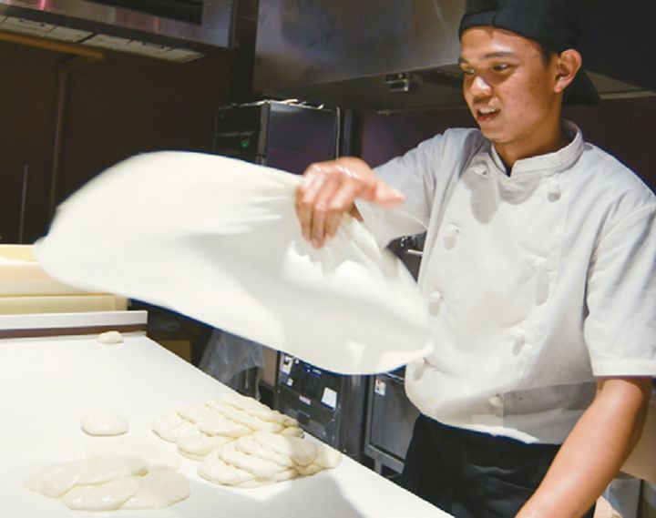 伝統的なストリートフード「ロティーチャナイ」の生地を空中で華麗に投げるパフォーマンス