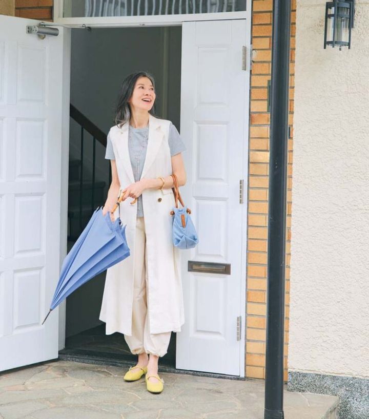 ジレ¥79,000、Tシャツ¥19,800／ともにティーチ、パンツ ¥16,500／ノーク、バッグ¥18,700／ヴィオラドーロ（ピーチ）、 フラットシューズ¥24,200／銀座かねまつ（銀座かねまつ６丁目 本店）、傘¥42,900／フォックスアンブレラズ（グリニッジ ショールム）、バングル¥25,300／ワンエーアールバイウノアエレ（ウノアエレ ジャパン）、ネックレス¥70,400／フローリアン（アッシ ュ・ペー・フランス）