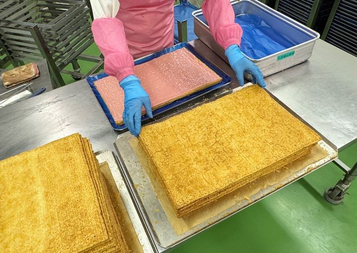 焼きあがったパイ生地に濃厚なクリームを重ねていく作業