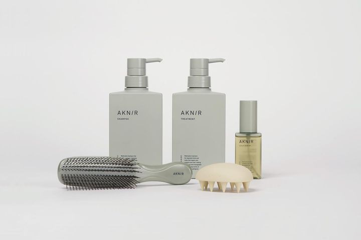 画像: （左奥から時計まわりに）薬用ヘアシャンプー［医薬部外品］300mL ¥4,800、薬用ヘアトリートメント［医薬部外品］300g ¥4,800、薬用ヘアスカルプセラム［医薬部外品］80ｍL ￥7,800、スカルプブラシ ￥2,300、シャンプーブラシ ¥7,900／すべてAKNIR 出典元：aknir.jp