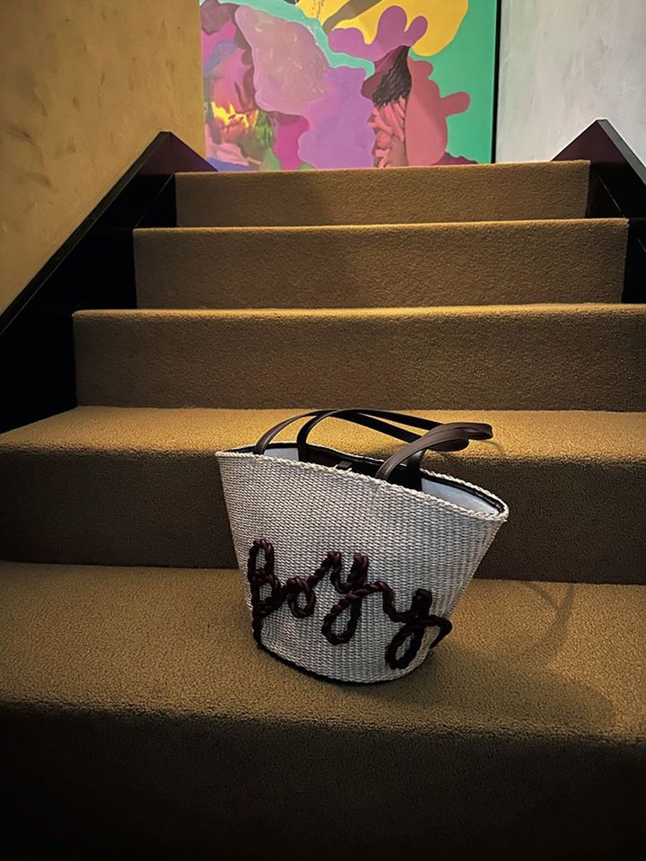 ボーイのラフィア素材のバッグ。スクリプト体のロゴが遊び心を添えている。