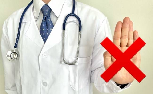 バツマークを押し出す医師のイメージ