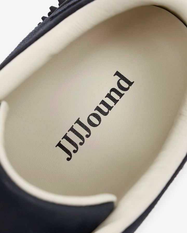 また、ライニングのバターイエローとシューレースの色味をリンクさせるなど、ディテールにも繊細なこだわりが込められている。インソールには JJJJound のブランディングがあしらわれ、特別なコラボレーションモデルであることをさりげなく主張する。