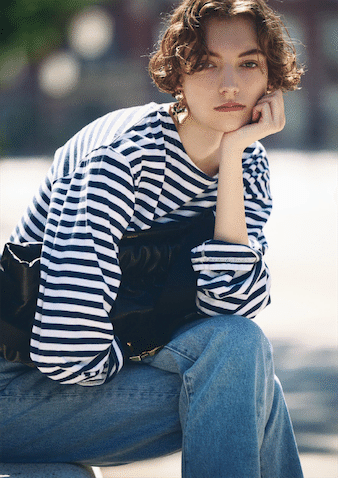 デニム＋ロンTを女っぽく見せるため 手首の細さを引き立てるルーズなボーダー：●ボーダーカットソー 10,780円／THE SHINZONE（Shinzone ル ミネ新宿店） デニムパンツ 16,500円／AKTE ピアス 999円 ／H＆M（H＆M カスタマーサービス） ボディバッグ 187,000 円／ザンケッティー、オレンジストラップサンダル 49,500円／ネブローニ（ともにプルミエ アロンディスモン）■ウエストにINしてできる腰まわりの余りも、メンズライクなサイズならでは。