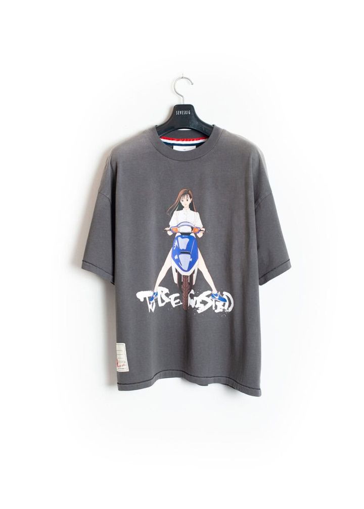 中央に力強く配置されたグラフィックと、“TO BE TWISTED”のロゴが印象的。背面には「AGING IS A UNIQUE JOURNEY TO BECOMING YOUR TRUE SELF」のメッセージをプリント。