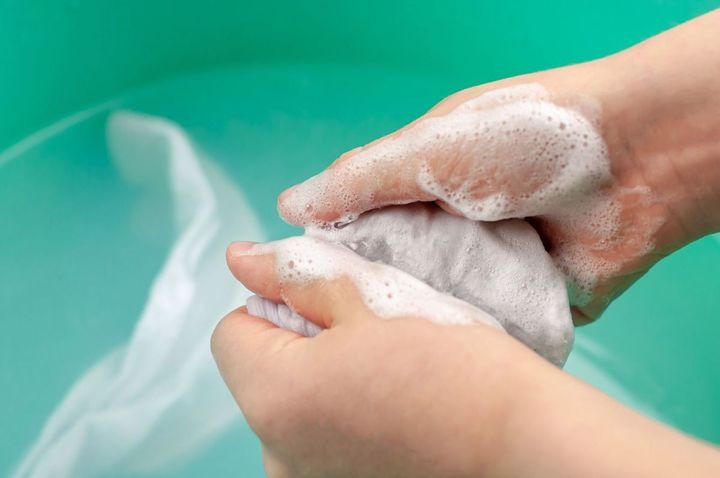 洗濯物を手で洗う子どもの手