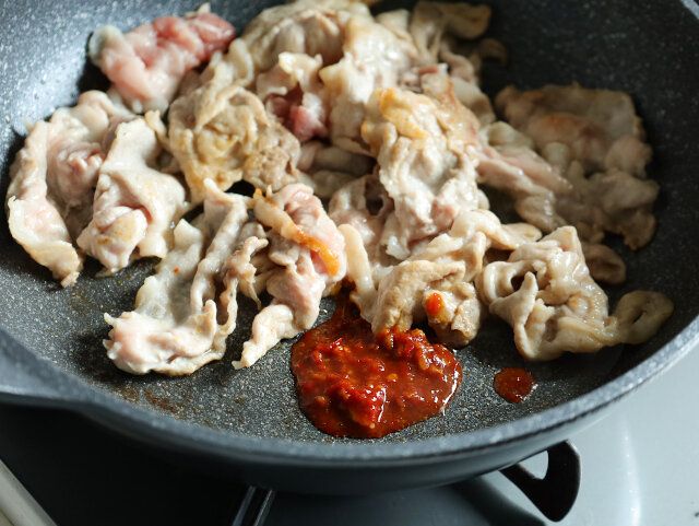 熱したフライパンで豚肉を炒め、豆板醤を入れる。
