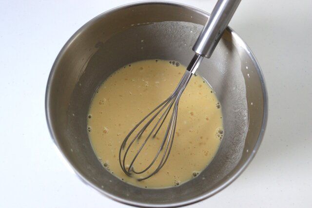 ボウルにたこ焼き粉を入れ、水を少しづつ入れてダマが出来ないように混ぜる。卵も割り入れて、よく混ぜ合わせる。