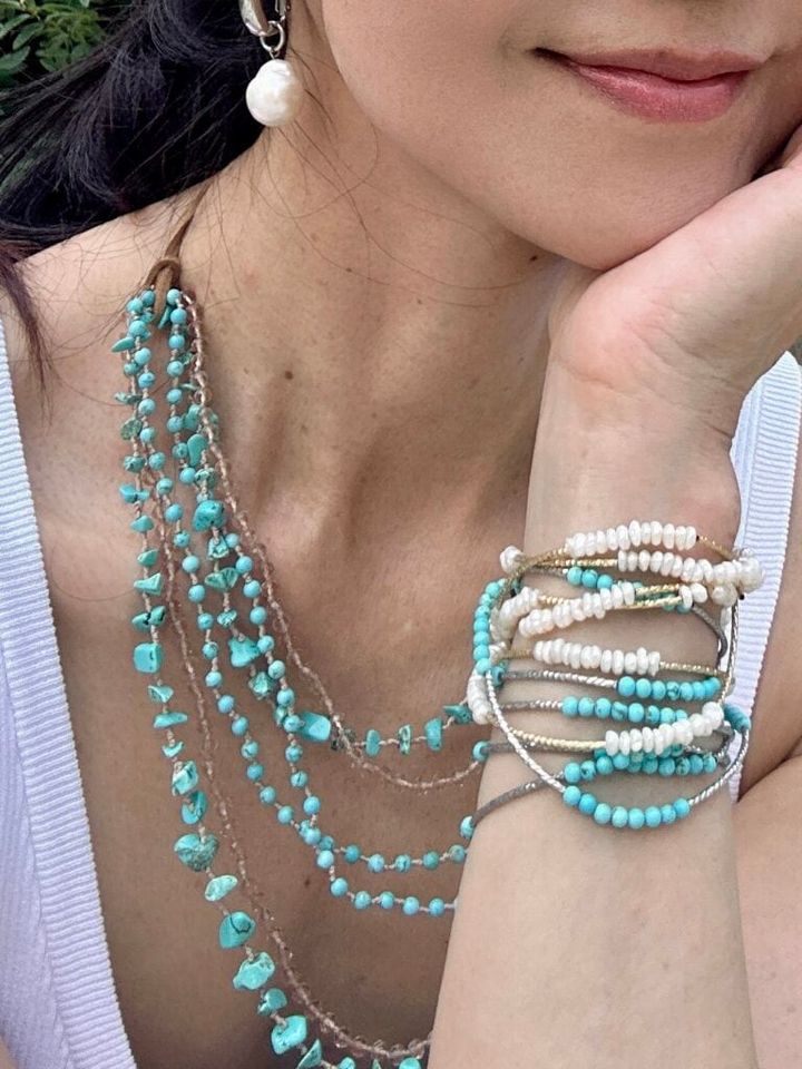ターコイズのネックレスにパールとターコイズを２本重ねにしたブレスレットをつければ、⼀気にお洒落感が出て、お出かけコーデの仲間⼊り。